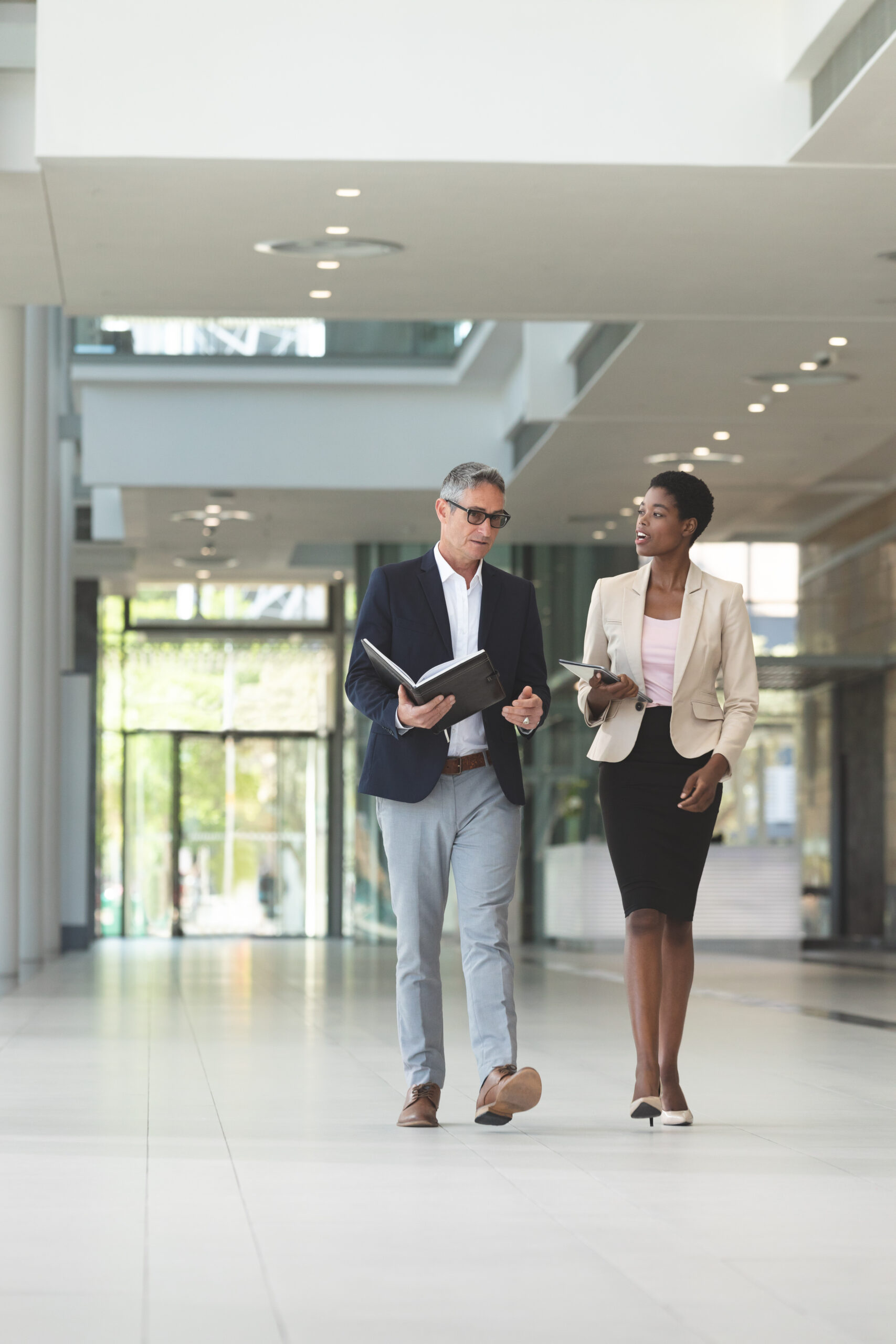 Diverse business people interacting with each other while walking in lobby office